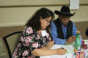 Ward 11 Trustee Karen Telford writing down feedback from Tom Durocher, an Elder from Fishing Lake Métis Settlement