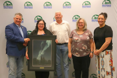 Leanne Gladue is presented with artwork in recognition of 25 years of service. She is joined by the Board Chair, Vice-Chair, Superintendent, and the Principal of Mistassiniy School.