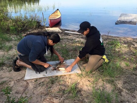 Fort Chipewyan student learning how to fillet a fish